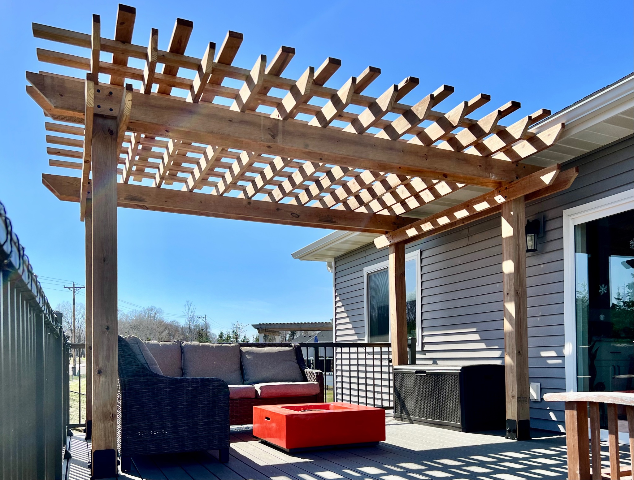 Large stained pergola with string lights on elevated deck