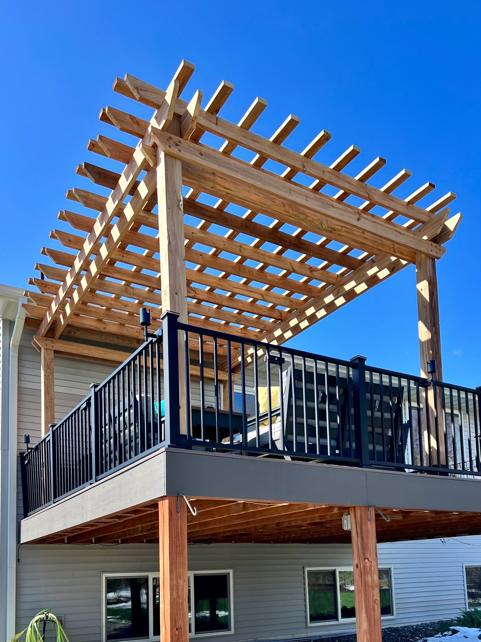 Elevated deck pergola against bright blue sky